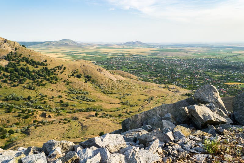 Punto di vista sopra una valle piana con i villaggi rurali circondati dai terreni coltivabili e dalle colline aride fotografie stock libere da diritti Punto di vista sopra una valle piana con i villaggi rurali circondati dai terreni coltivabili e dalle colline aride fotografie stock libere da diritti
