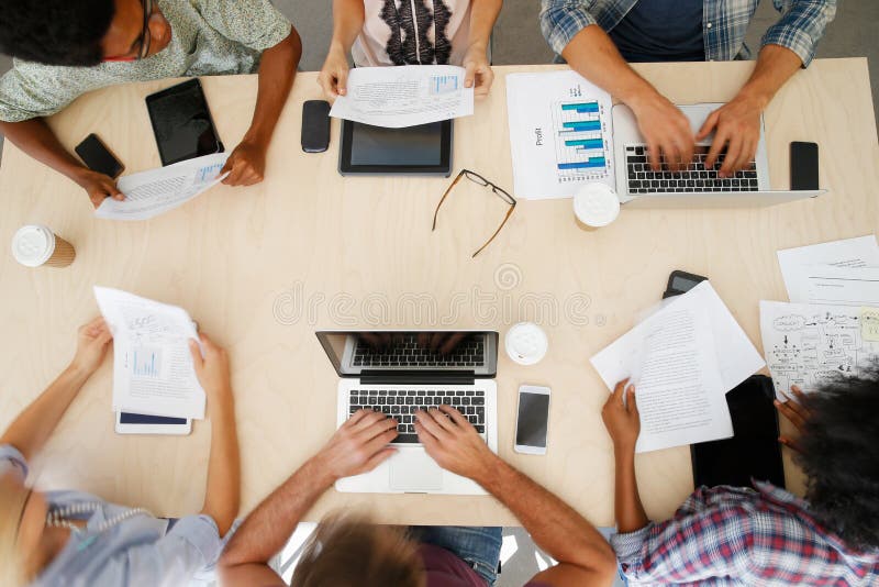 Overhead View Of Staff With Digital Devices In Meeting. Overhead View Of Staff With Digital Devices In Meeting