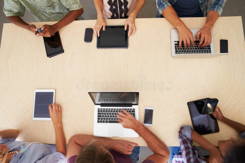 Overhead View Of Staff With Digital Devices In Meeting. Overhead View Of Staff With Digital Devices In Meeting