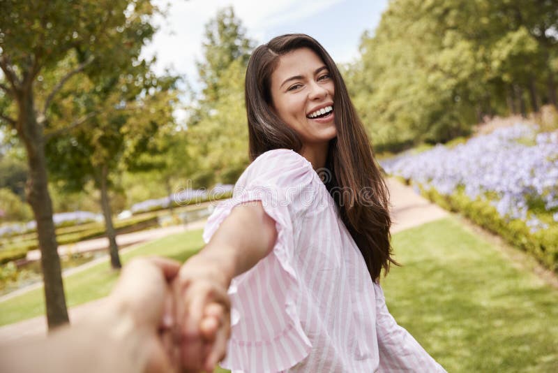 Punto di vista sparato delle coppie romantiche che camminano insieme nel parco immagini stock Punto di vista sparato delle coppie romantiche che camminano insieme nel parco immagini stock