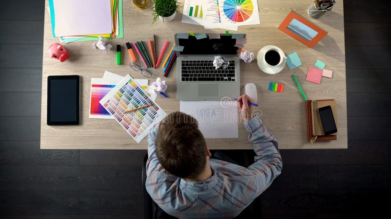 Punto di vista superiore dell'uomo di affari che cerca idea startup, scrivente sulla carta i suoi pensieri immagini stock libere da diritti Punto di vista superiore dell'uomo di affari che cerca idea startup, scrivente sulla carta i suoi pensieri immagini stock libere da diritti