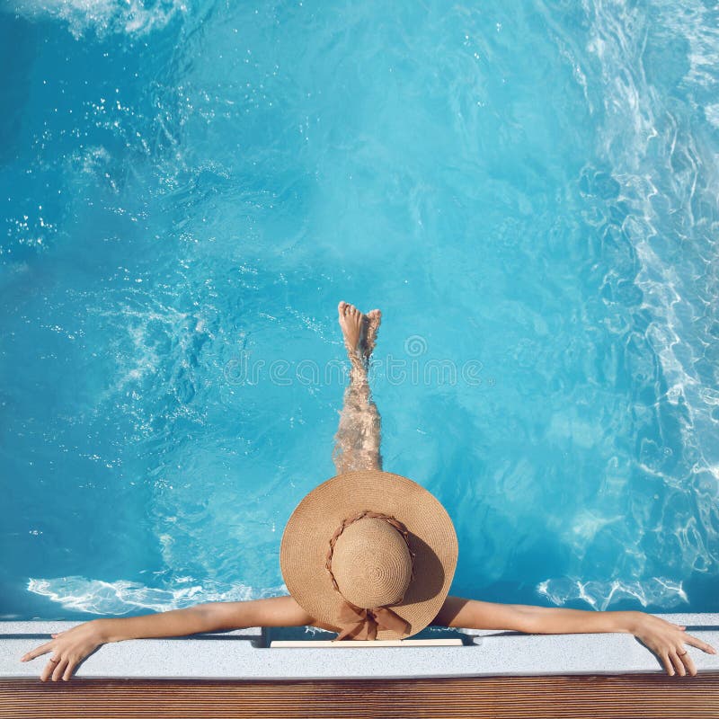 Punto di vista superiore della donna in cappello di paglia che si rilassa nella piscina al luxu fotografia stock libera da diritti Punto di vista superiore della donna in cappello di paglia che si rilassa nella piscina al luxu fotografia stock libera da diritti
