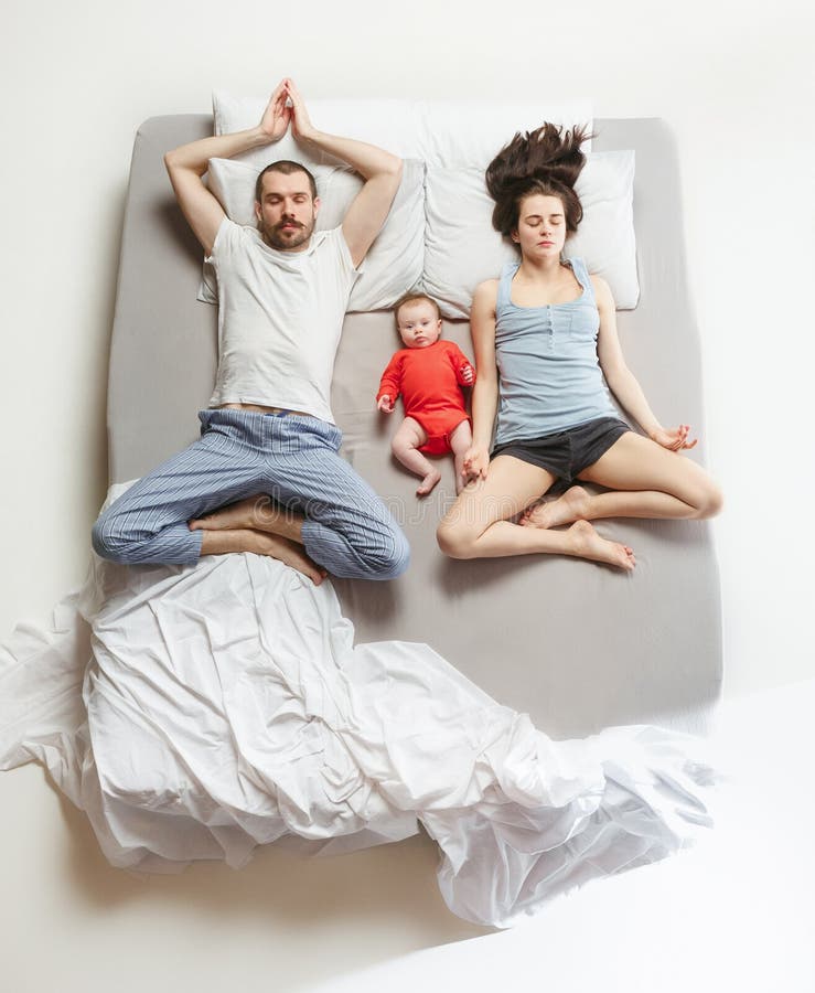 Punto di vista superiore della famiglia felice con un bambino neonato in camera da letto fotografia stock Punto di vista superiore della famiglia felice con un bambino neonato in camera da letto fotografia stock