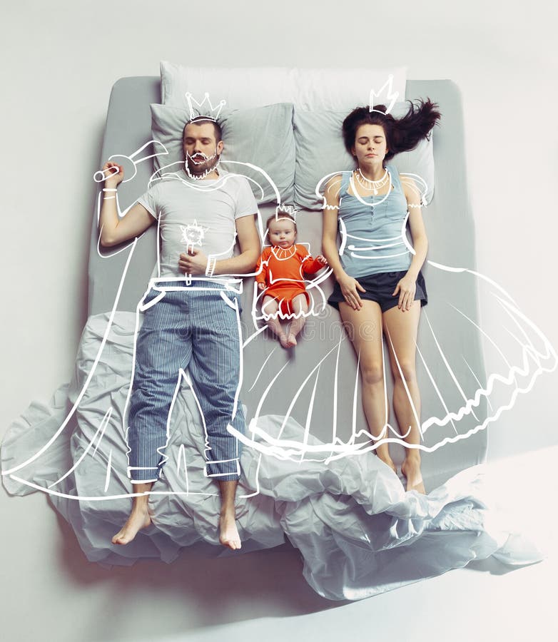 Punto di vista superiore della famiglia felice con un bambino neonato in camera da letto e nei loro sogni fotografia stock Punto di vista superiore della famiglia felice con un bambino neonato in camera da letto e nei loro sogni fotografia stock