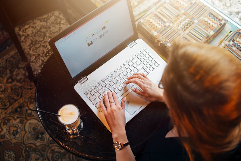 Punto di vista superiore di giovane studentessa che lavora al computer portatile che si siede alla tavola fotografie stock libere da diritti Punto di vista superiore di giovane studentessa che lavora al computer portatile che si siede alla tavola fotografie stock libere da diritti