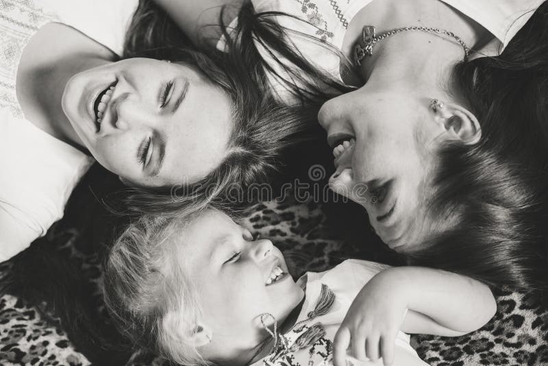 Punto di vista superiore di giovani ragazze delle sorelle che ridono felicemente fotografia stock libera da diritti Punto di vista superiore di giovani ragazze delle sorelle che ridono felicemente fotografia stock libera da diritti