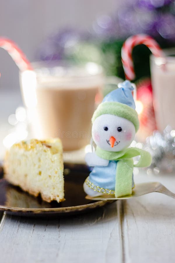 Winter snowman sitting near the plate with christmas pie. Winter snowman sitting near the plate with christmas pie.