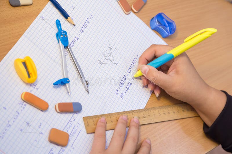 Pupil& x27;s hand close-up solve a geometry example in a notebook. royalty free stock photos