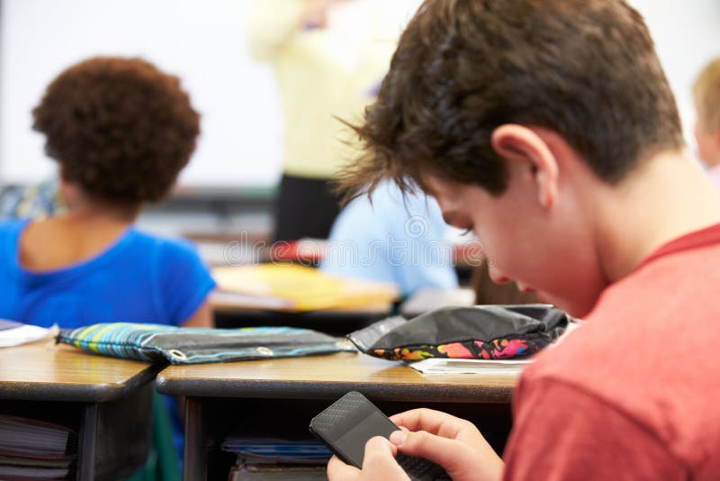 Pupil Sending Text Message On Mobile Phone In Class royalty free stock images