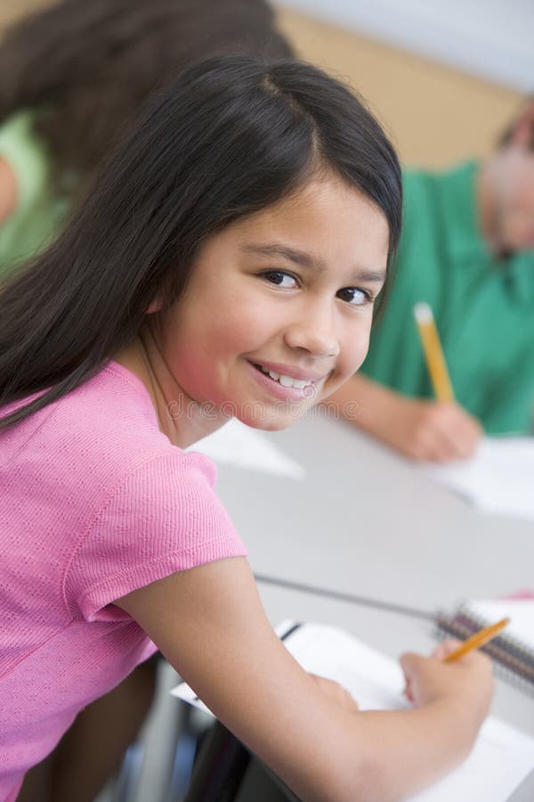 Pupilla femminile nell'aula della scuola elementare fotografie stock Pupilla femminile nell'aula della scuola elementare fotografie stock