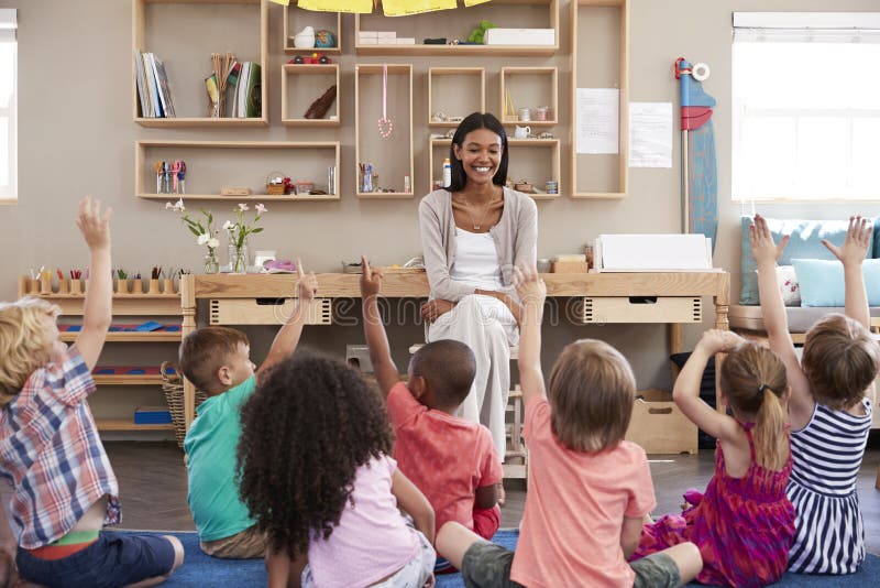 Pupils At Montessori School Raising Hands To Answer