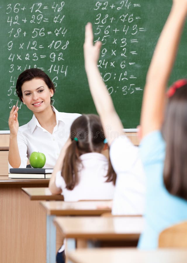 Pupils put their hands up to answer stock photo