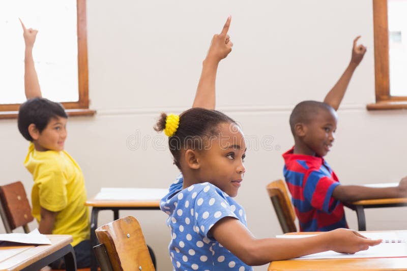 Pupils raising hand in classroom royalty free stock photography
