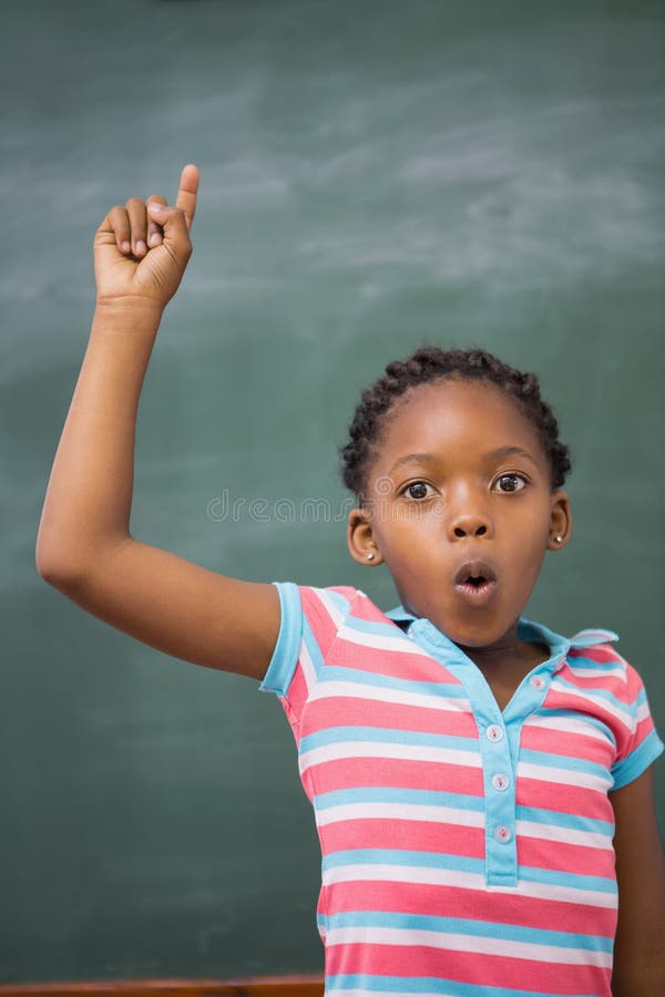 Pupils raising hand in classroom royalty free stock photography