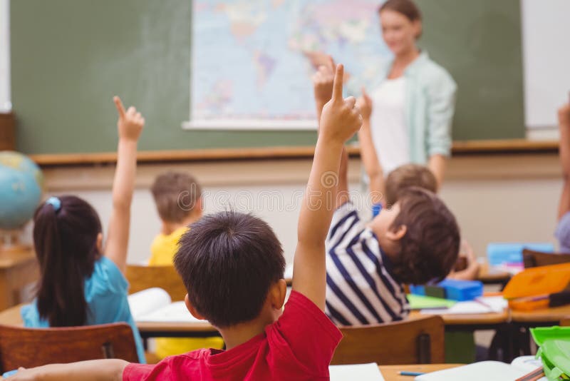Pupils raising hand during geography lesson in classroom royalty free stock photos