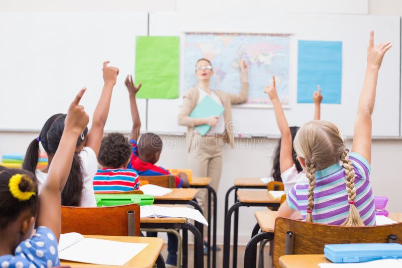 Pupils raising hand during geography lesson in classroom royalty free stock image