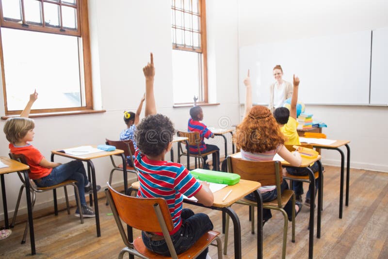 Pupils raising their hands during class royalty free stock photo