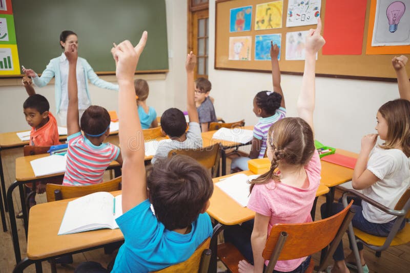 Pupils raising their hands during class royalty free stock image