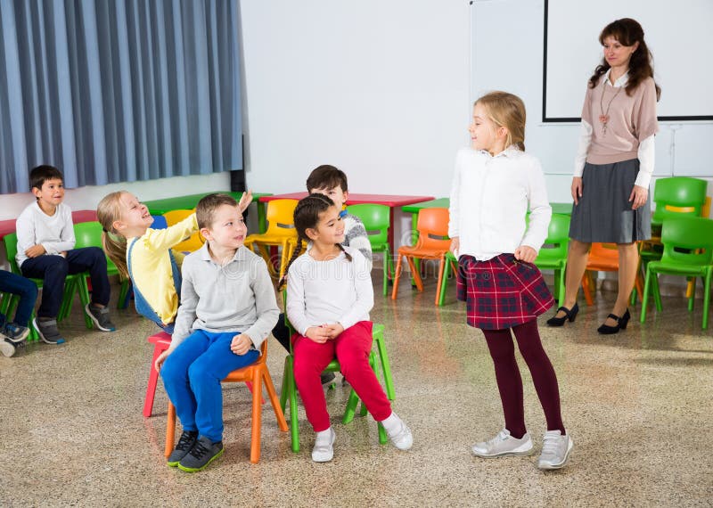 pupils-teacher-playing-musical-chairs-happy-laughing-primary-school-having-fun-break-their-193948070.jpg