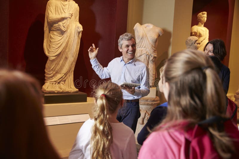 Pupils And Teacher On School Field Trip To Museum With Guide royalty free stock photo Pupils And Teacher On School Field Trip To Museum With Guide royalty free stock photo