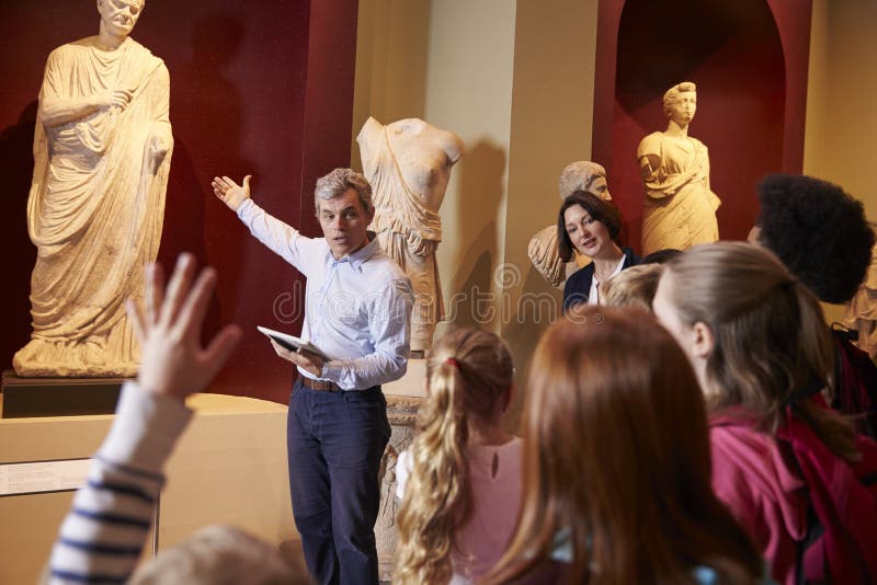 Pupils and Teacher on School Field Trip To Museum with Guide Editorial