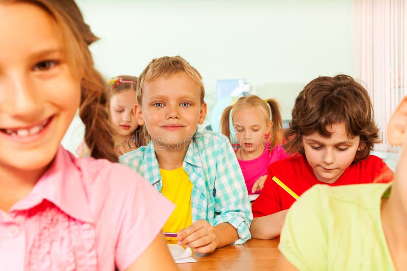 Pupils write in exercise books during lesson stock images