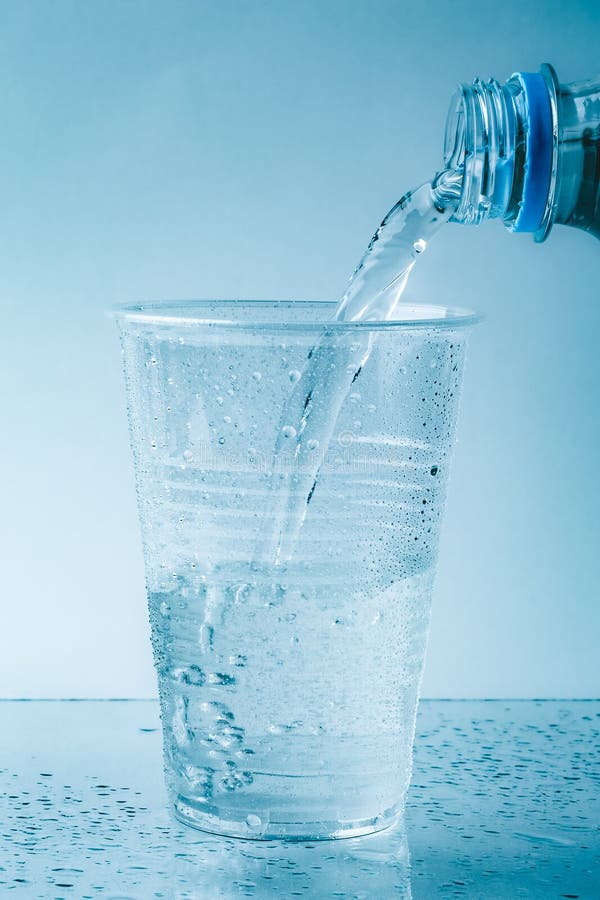 Pure Fresh Water Is Pouring Into Glass Or Plastic Cup In Drops Close Up