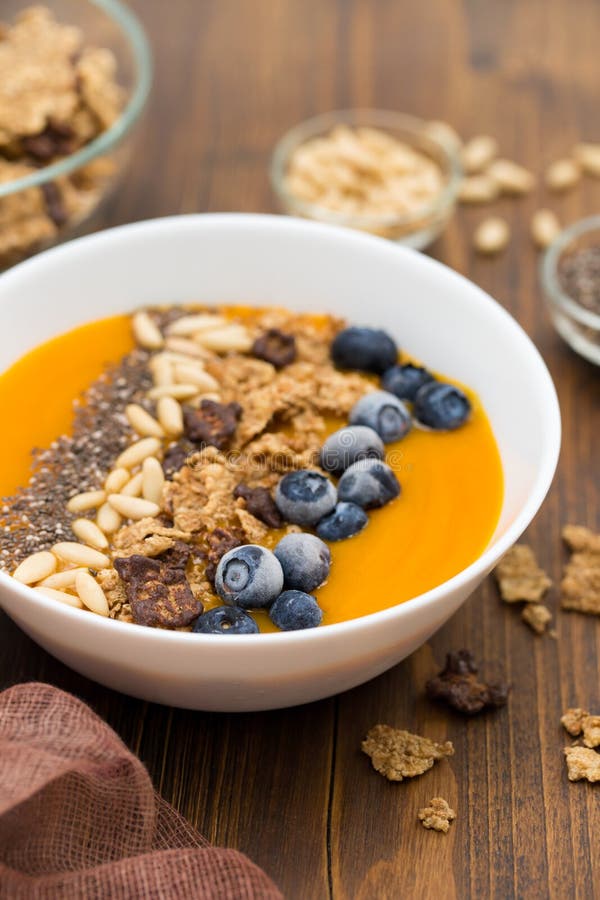 Puree van mango met granola, chia en bessen in witte kom royalty-vrije stock fotografie Puree van mango met granola, chia en bessen in witte kom royalty-vrije stock fotografie