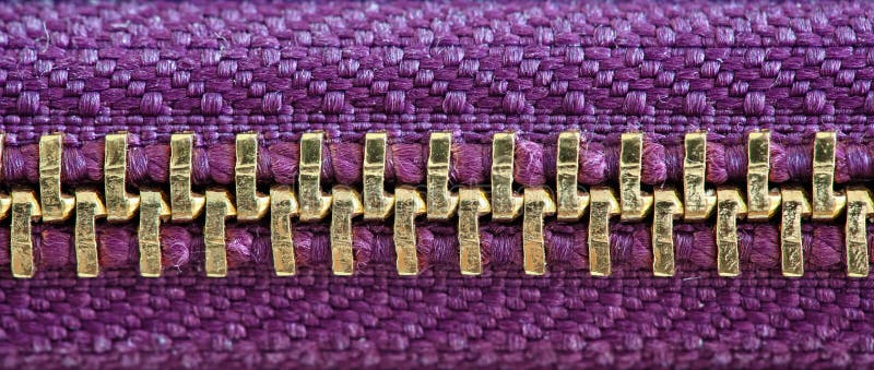 Purple and gold zipper tightly closed binding together two layers of fabric textile under high magnification close detail royalty free stock image