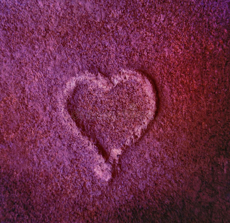 Purple colored Heart shape in the old brick stone from up close. Purple colored Heart shape in the old brick stone from up close