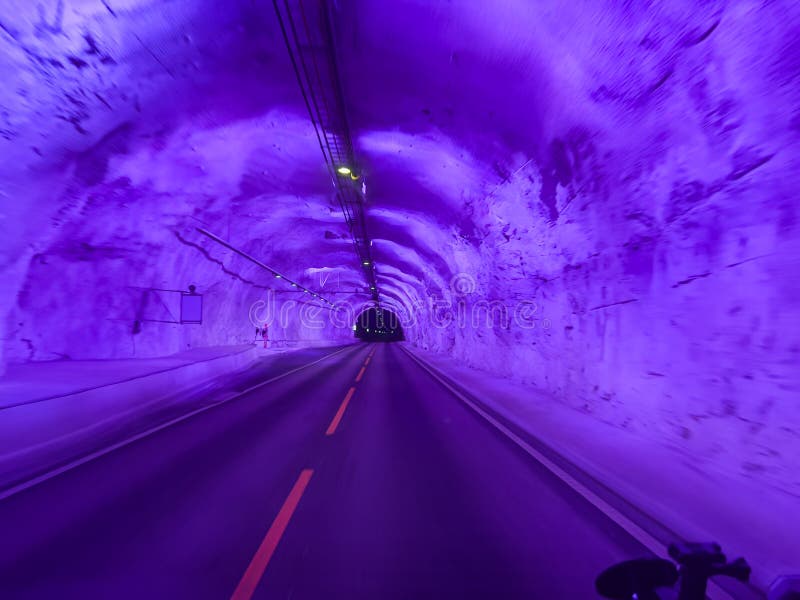 Purple illuminated road inside the laerdal tunnel in norway stock photography