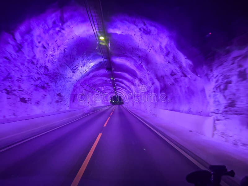 Purple illuminated road inside the laerdal tunnel in norway royalty free stock photo