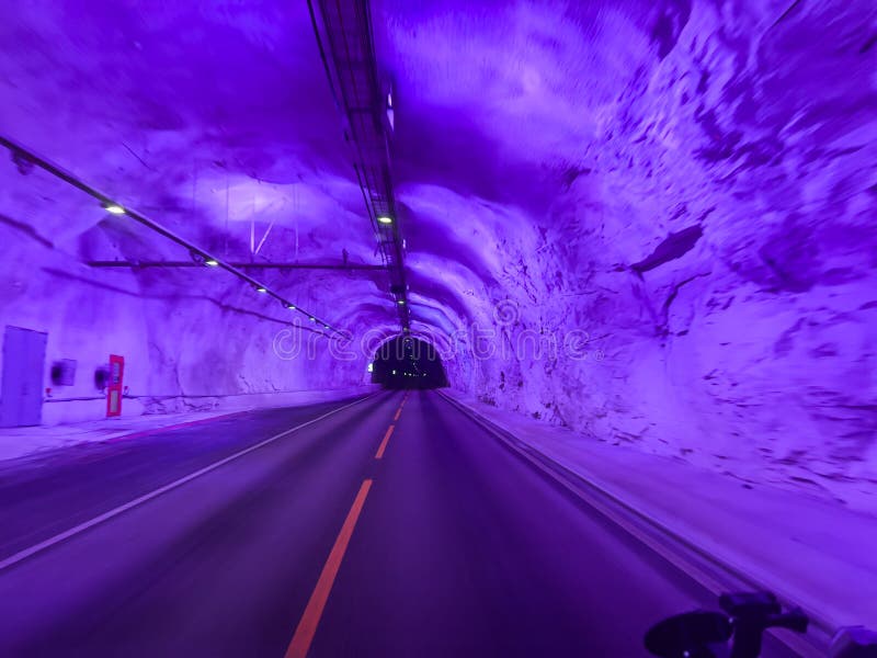 Purple illuminated road inside the laerdal tunnel in norway royalty free stock photo