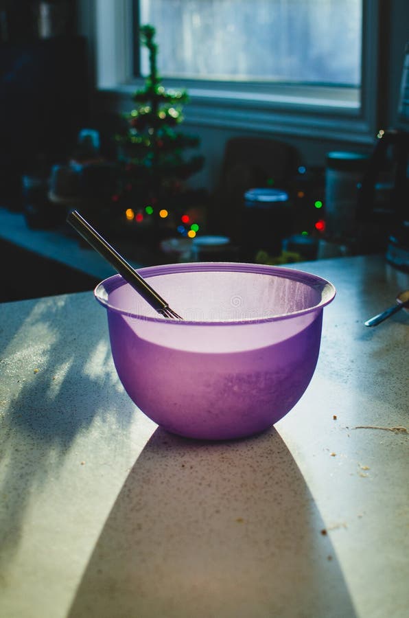 Purple Mixing Bowl and Whisk in the Soft Kitchen Light Stock Image