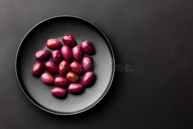 Purple olives on black plate, copy space royalty free stock image Purple olives on black plate, copy space royalty free stock image