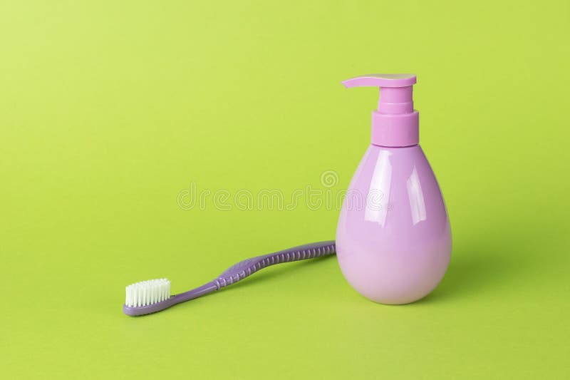 Purple toothbrush and toothpaste on a green background stock photos