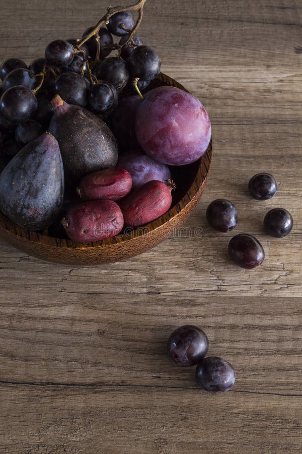 Purpurrote Frucht in einer hölzernen Schüssel lizenzfreie stockfotos Purpurrote Frucht in einer hölzernen Schüssel lizenzfreie stockfotos