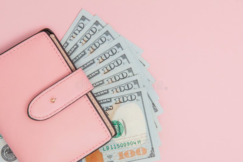 Purse with one hundred dollars banknotes on pink background. Flat lay, top view, copy space