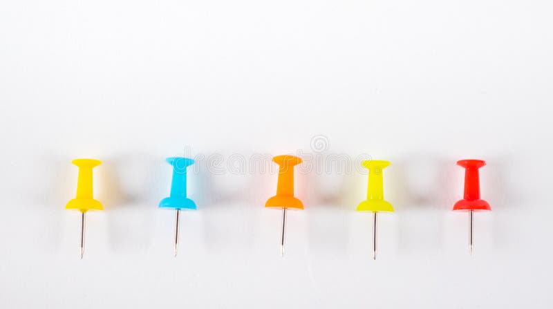 Push pins in white background or wallpaper