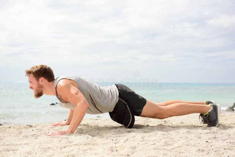Push-UPS - mankondition som övar på stranden royaltyfri bild Push-UPS - mankondition som övar på stranden royaltyfri bild