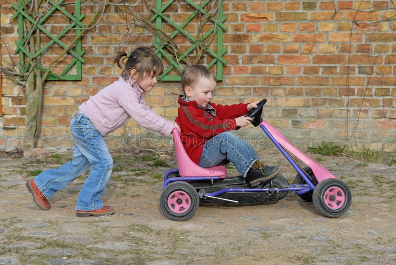 Mellizos emprendedor su hermano en juguete auto.