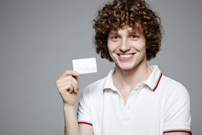 Portrait of the young smiling man holding blank credit card, on gray background. Portrait of the young smiling man holding blank credit card, on gray background