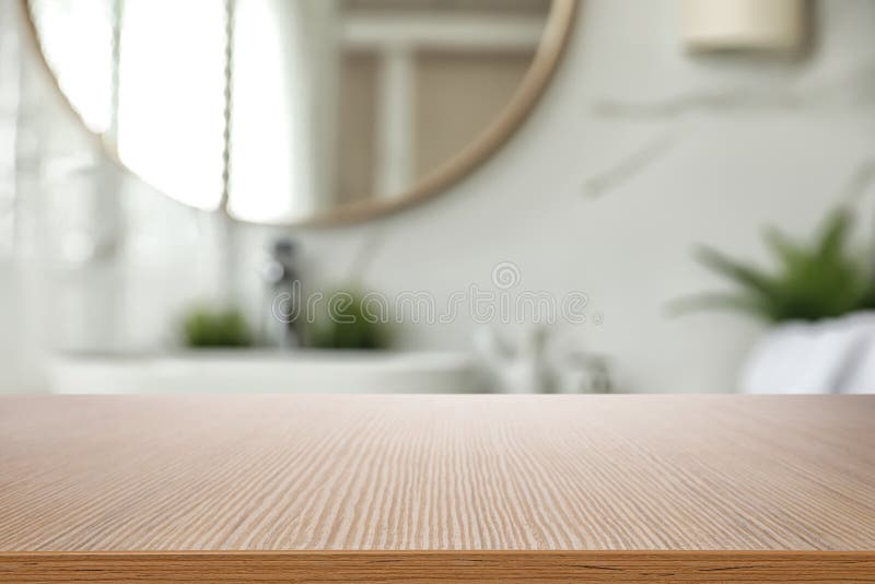 Pusty drewniany stół i zamazany widok wnętrza łazienki