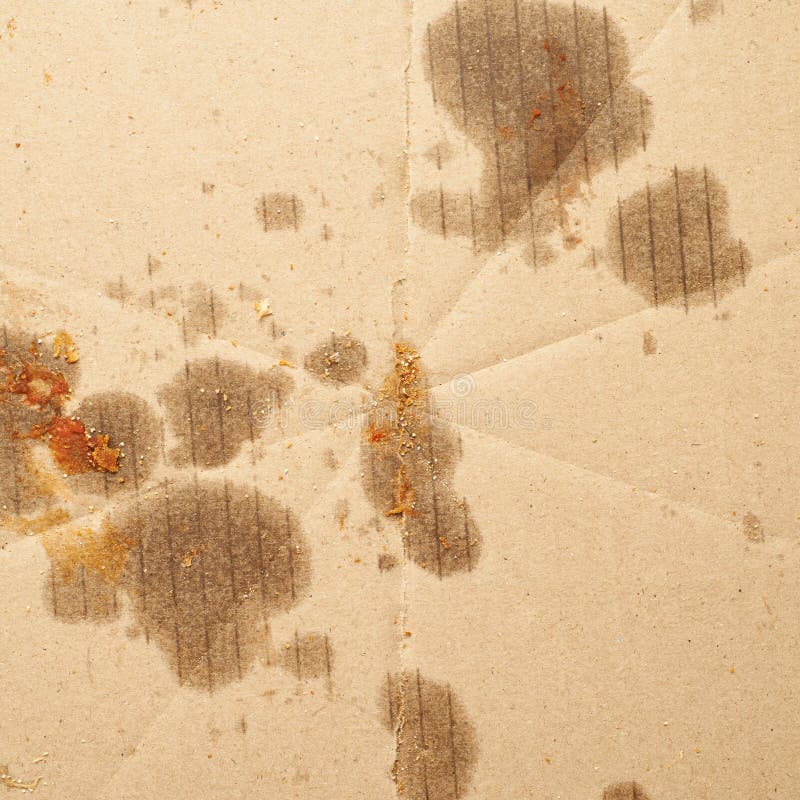 Empty cardboard with the stains of fat and pizza crumbs as a background close-up texture composition. Empty cardboard with the stains of fat and pizza crumbs as a background close-up texture composition