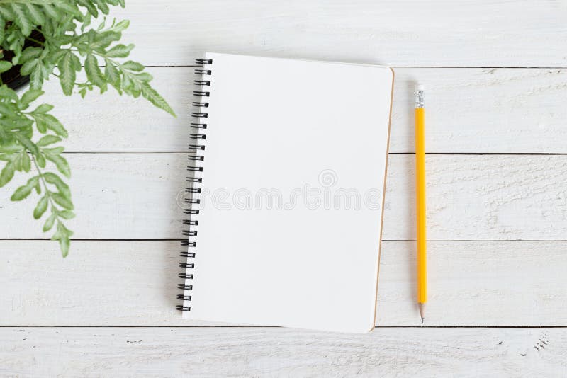Pusty notatnik z i ołówek na białym drewnie, mieszkanie nieatutowa notatnik dla twój wiadomości fotografia