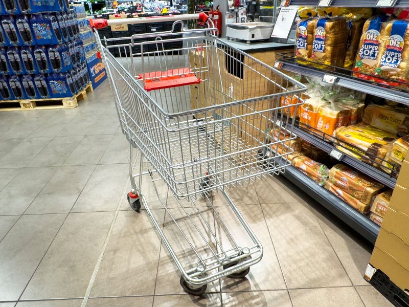 Pusty wózek zakupowy w korytarzu spożywczym z wyświetlaczem chleba i napojów bezalkoholowych zdjęcia stock