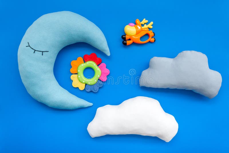 Put baby into bed with moon pillow, clouds and toy on blue background top view royalty free stock photos Put baby into bed with moon pillow, clouds and toy on blue background top view royalty free stock photos