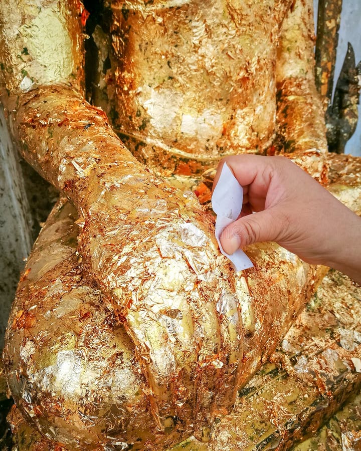 Put Gold Leaf Onto the Buddha Image,the Buddha Statue ,to Gild T Stock