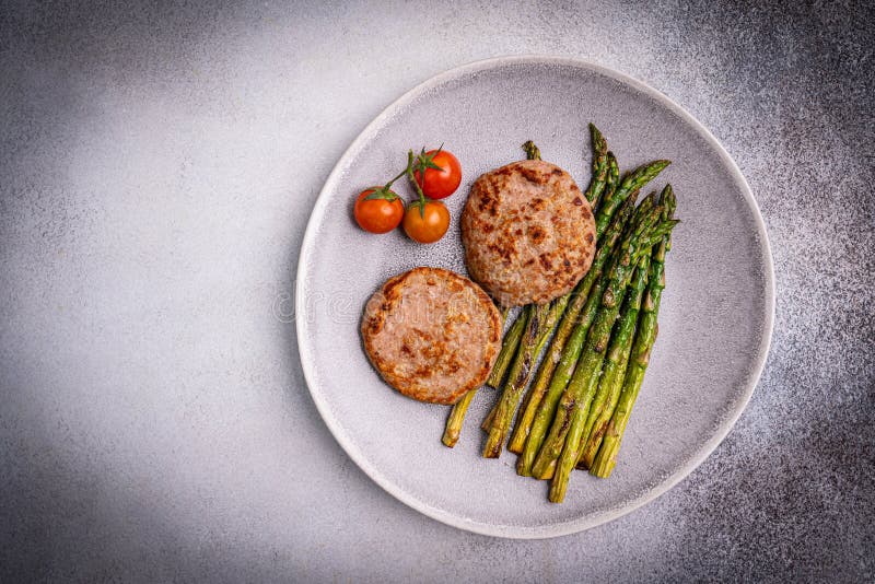 Putenburgern oder -haltern, gegrillt, grüner Spargel lizenzfreie stockbilder