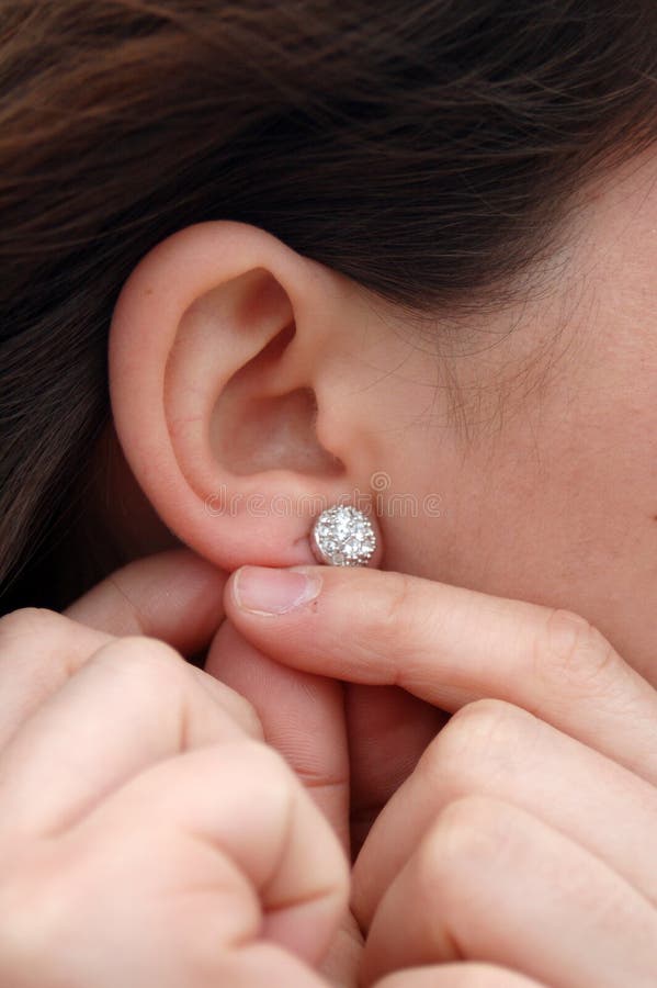 Putting earrings on stock image. Image of earlobe, hands 2533097